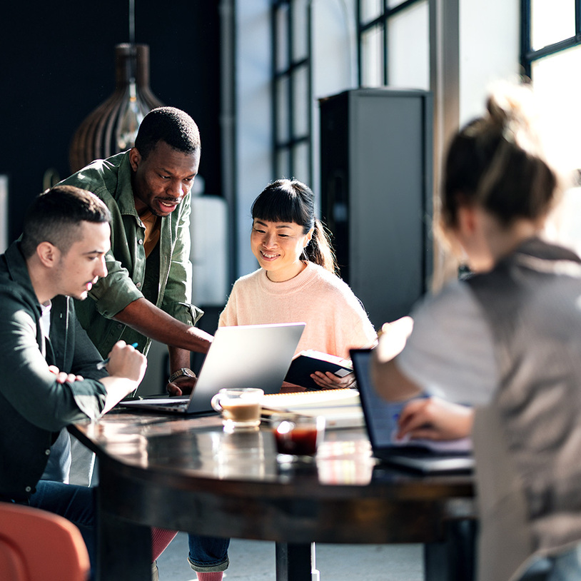 Personengruppe am Schreibtisch mit Laptops