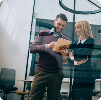 Foto von Mann und Frau im Büro die auf einen Tablet schauen