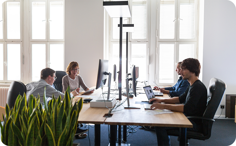 Büroszene mit Mitarbeitern an zwei Schreibtischen